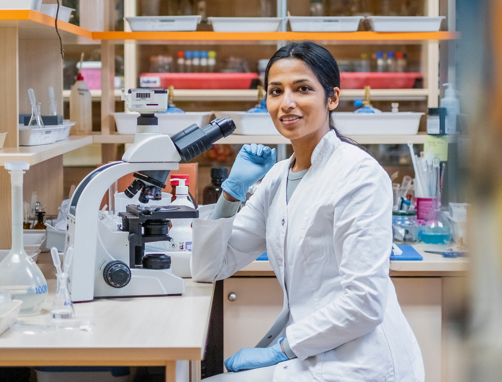 Femme scientifique utilisant un microscope en laboratoire