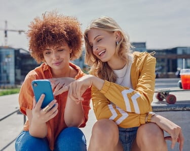deux femmes regardant ensemble du contenu sur leur téléphone deux femmes regardant ensemble du contenu sur leur téléphone