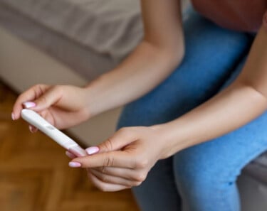 vrouw kijkt naar het resultaat van haar zwangerschapstest vrouw kijkt naar het resultaat van haar zwangerschapstest